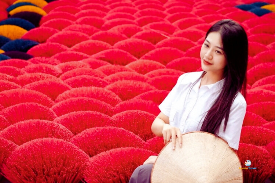 Vietnamese girl posing amid colorful incense sticks in Quang Phu Cau Village – Auasia Travel